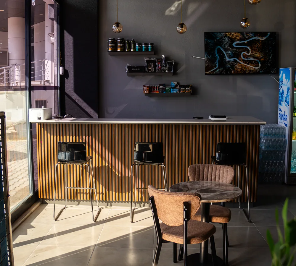 Terra’nın gün ışığı alan kafe bölümündeki masa, koltuklar ve ahşap bar